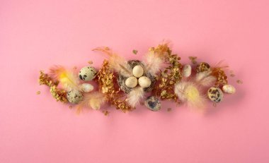 Paskalya kompozisyonu olarak bıldırcın yumurtaları, tüyler ve kurumuş çiçekler. Üst görünüm.