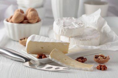 Beyaz ahşap bir masada cevizli Camembert peyniri..
