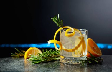 Siyah arka planda limon ve biberiyeli cin tonik kokteyli. Boşluğu kopyala.