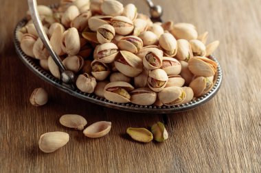 Eski ahşap bir masada tuzlu şam fıstığı.