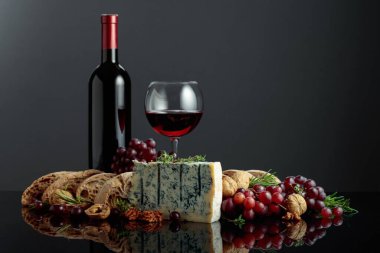 Ciabatta, ceviz, üzüm ve kırmızı şaraplı Gorgonzola peyniri. Geleneksel İtalyan küflü peyniri. Siyah yansıtıcı arka planda meyveler ve aromatik otlar..