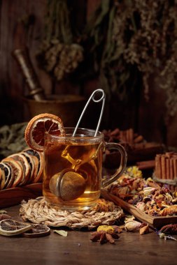 Bir fincan bitkisel çay, çeşitli kurutulmuş bitkiler, çiçekler ve baharatlar. İçindekilerle çay ve kurutulmuş narenciye..