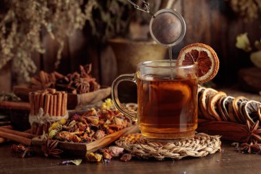 Bir fincan bitkisel çay, çeşitli kurutulmuş bitkiler, çiçekler ve baharatlar. İçindekilerle çay ve kurutulmuş narenciye..