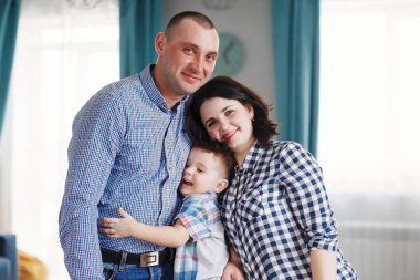 Aile Anne, baba ve oğul mutfakta masada kırmızı yeşil ve sarı sebze yemek