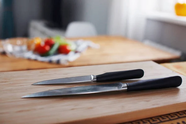 Dva Nože Popředí Pro Vaření Zeleniny Leží Dřevěný Stůl — Stock fotografie