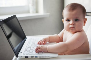 Bebek bir dizüstü bilgisayar ile beyaz bir sandalyesi oturur ve eller üstünde belgili tanımlık klavye metin yazarak ekrana, görünüyor.