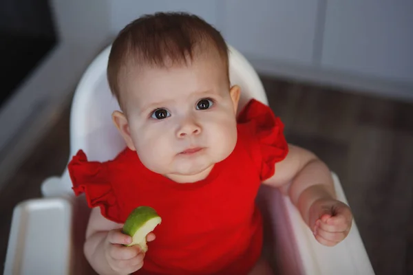 Söt Baby Röd Klänning Med Svullna Kinder Sitter Vit Barnstol — Stockfoto