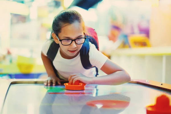 Sevimli Genç kız hava hokeyi arcade oyun makinesi bir eğlence parkında çalış..