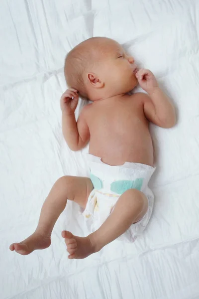 Bebé Pañal Descansa Sobre Una Sábana Blanca —  Fotos de Stock
