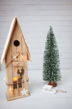 Oyuncak evi ve beyaz ahşap zemin üzerinde Noel ağacı.
