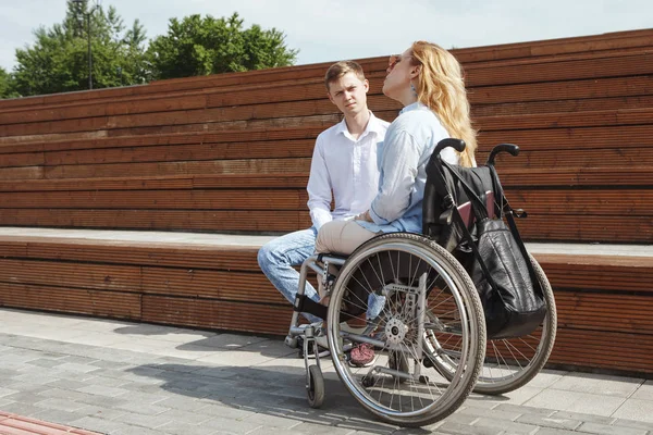 Женщина Инвалидном Кресле Молодой Человек Разговаривают Сидя Ступеньках Городского Парка — стоковое фото