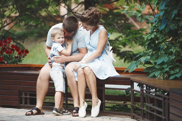 若い幸せな家族 母と金髪の少年が公園の木製ベンチの上に座って 家族の幸福と健康的なライフ スタイルのコンセプト — ストック写真