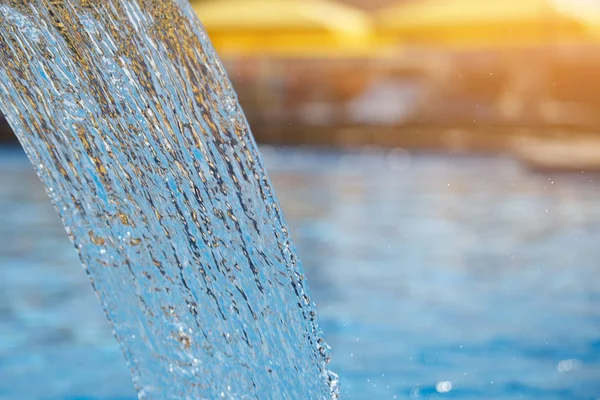 Havuzda su akışı. Mavi yüzey, sprey, yakın çekim. Seçilen odak.