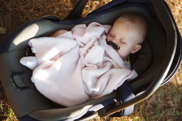 金髪の赤ん坊は甘く暗い青ベビーカーで眠る — ストック写真