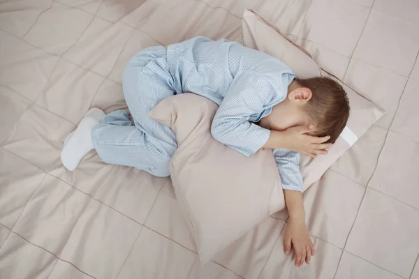 Little Boy Blue Pajamas Lies Curled Ball Hugs Pillow Bed — Stock Photo, Image