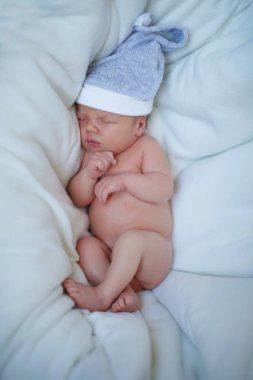 Yeni doğan bebek mavi bir kap içinde beyaz bir yatak örtüsü üzerinde yatıyor ve uyur. Bir mutlu çocukluk, annelik, emzirme kavramı.