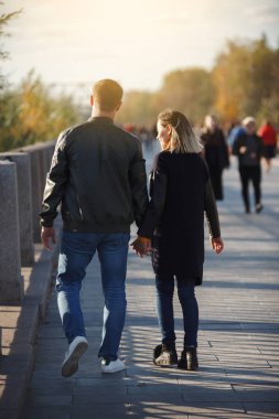 Genç çift erkek ve kız sonbahar parkta yürümek. Sonbahar. Genç adam ve kadın dışında. Mutlu aile kavramı. Sarı ağaç ve yaprak.