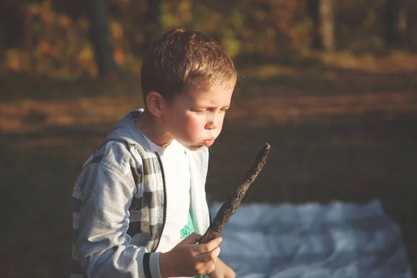 Jongen Blaast Een Smeulende Tak Herfst Bos — Stockfoto