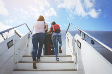 Anne bir çanta ve bir kızı kırmızı sırt çantası yolcular ile gitmek uçak rampa için Havaalanı sahada.