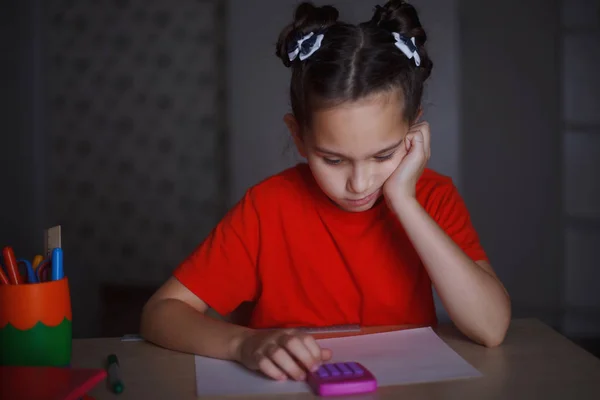 Een Jong Meisje Een Oranje Shirt Studeren Aan Een Bureau — Stockfoto