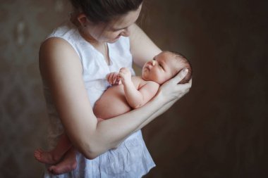Genç şirin Anne kucağında yeni doğan oğlu uyku ve gülümseyerek bakar tutar. Bir mutlu çocukluk, annelik, emzirme kavramı.