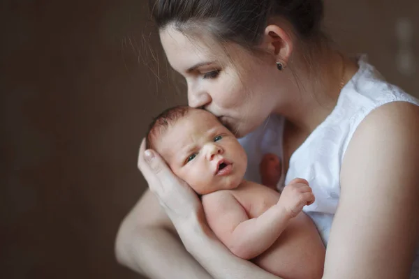 Young Cute Mother Holds Her Arms Kisses Sleeping Newborn Son — Stock Photo, Image