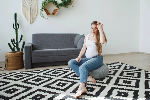 Mooie Zwangere Vrouw Met Lange Haren Een Wit Vest Zit — Stockfoto