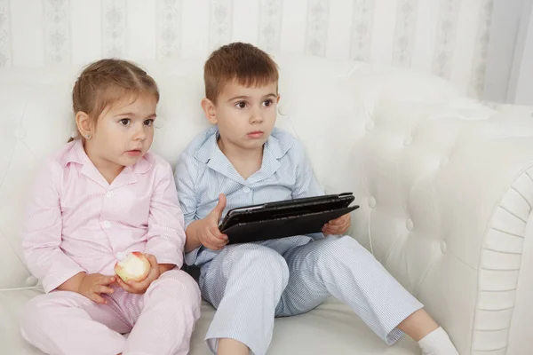 Brother Sister Pink Blue Pajamas Sit White Sofa Look Tablet — Stock Photo, Image