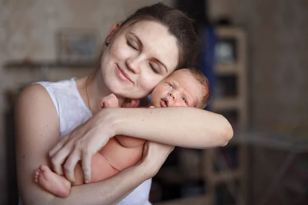 かわいい若い母親は彼女の腕で生まれたばかりの息子を保持して 笑みを浮かべてします 幸せな子供時代 母乳育児のコンセプト — ストック写真