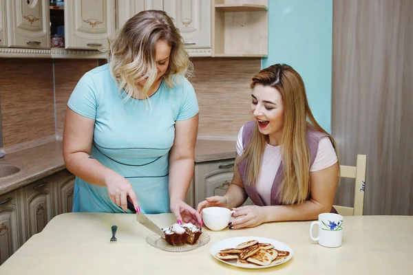 两个女朋友在厨房里的女人玩得很开心, 吃东西. — 图库照片