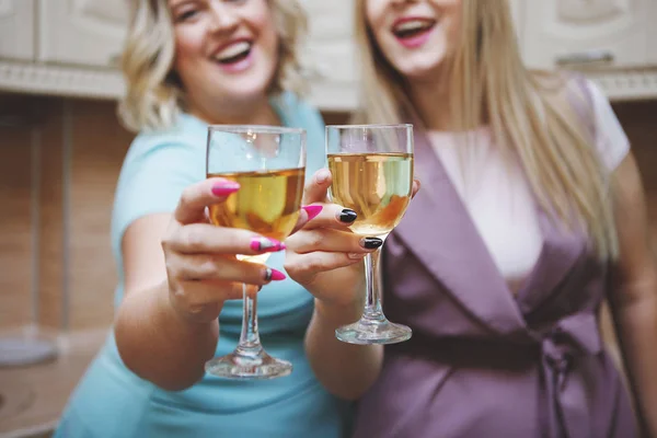 Dos amigas mujeres en la cocina se divierten y beben vino . — Foto de Stock