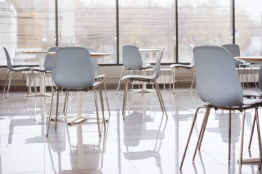 Açık alan geniş pencere, parlak iç arka plan ve şehrin modern bir ofis plastik sandalyeler.