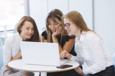 Ofis personel ekibi. Üç iş kadınları ile bir dizüstü bilgisayar bir masada oturan ve kurumsal gelişim kavramı gelecek için planlıyoruz. Ekip çalışması. Cinsiyet eşitliği.