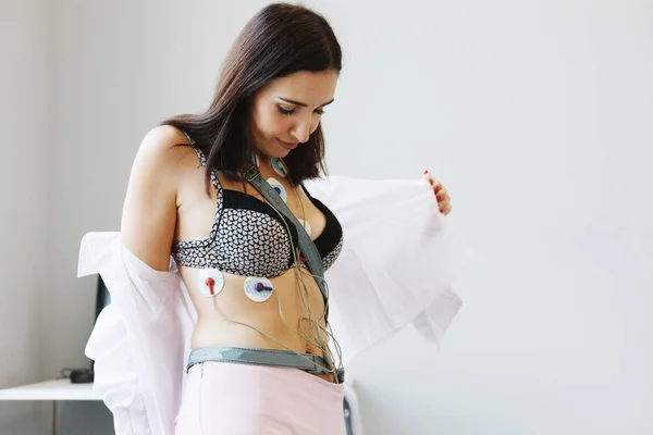 Kadın vücudunda bir elektrokardiyogram günlük izlenmesi için holter monitör aygıtı sensörleri ile. Kalp hastalıklarının tedavisi. Sağlık kontrolü.