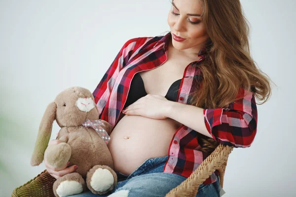 Mooie Zwangere Vrouw Met Lange Haren Een Plaid Shirt Zit — Stockfoto