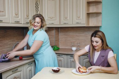 Kadının mutfakta iki kız arkadaşım eğleniyor ve yemek yeme.