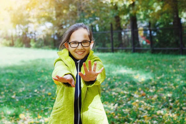 年轻漂亮的少女与眼镜在秋天的院子里散步和欢欣鼓舞 — 图库照片