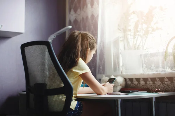 Tiener Meisje Zit Aan Een Tafel Tegenover Een Venster Iets — Stockfoto