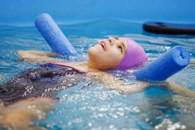 Üç-yıl-yaşlı çocuk mavi bir kap ve yüzme gözlüğü erkek bir eğitmen yardımıyla bir havuzda boğulmuş olduğunu. Aquatherapy. Su rehabilitasyon. Dalış. Sağlıklı yaşam tarzı.