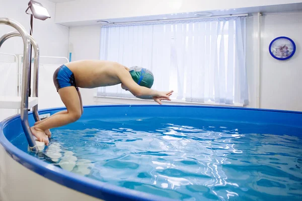 Springt Der Junge Mit Der Mütze Von Der Leiter Pool — Stockfoto