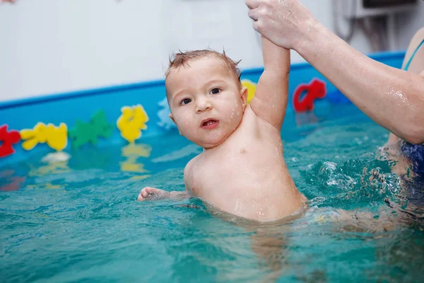 Anne ile bebek egzersizleri havuzun içinde. Sağlıklı yaşam, su rehabilitasyon, aquatherapy.