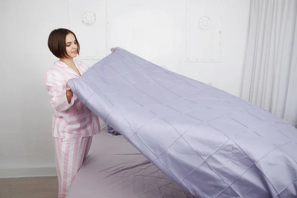 ピンクのパジャマで若いかわいい髪の女性枕と青い寝具ベッドになります — ストック写真