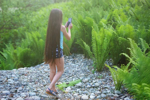 Дівчина Підліток Довгим Волоссям Дивиться Смартфон Тлі Папороті Заростей — стокове фото