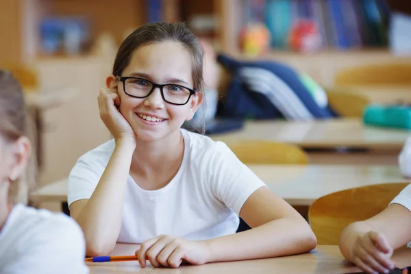 Nettes Teenie Mädchen Mit Brille Sitzt Der Schule Schreibtisch Und — Stockfoto