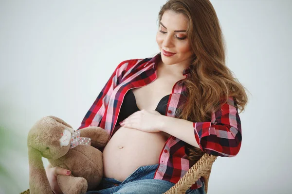 Mooie Zwangere Vrouw Met Lange Haren Een Plaid Shirt Zit — Stockfoto