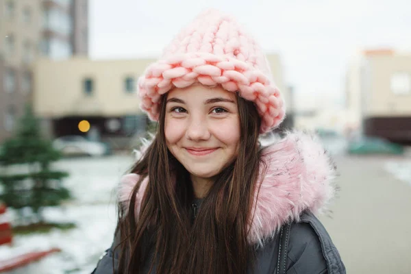 おしゃれなピンクのニット帽で髪の長い若いきれいな女の子 代の幸せ笑顔し 冬の外の生活を楽しんでいます クローズ アップ — ストック写真