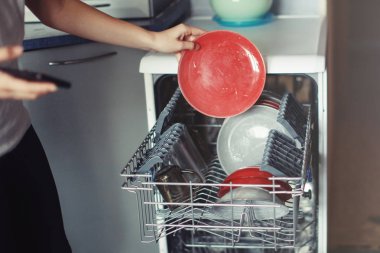 Yıkandıktan sonra temiz bulaşıkla bulaşık makinesini aç.