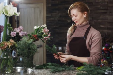 Önlük kadında çok orta yaşlı çiçekçi bir buket çiçek salon için bir düğün ya da yıldönümü şenlikli bir hediye yapar.