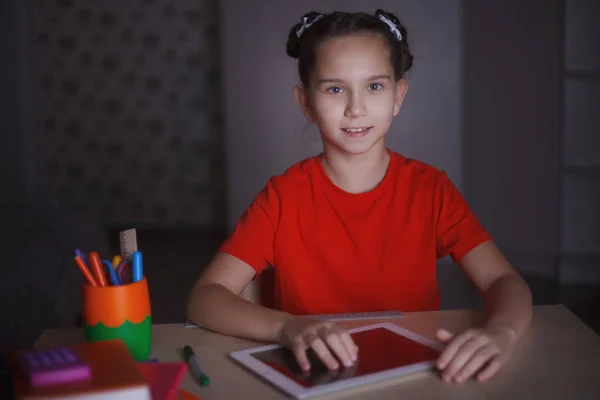 Een Jong Meisje Een Oranje Shirt Studeren Aan Een Bureau — Stockfoto