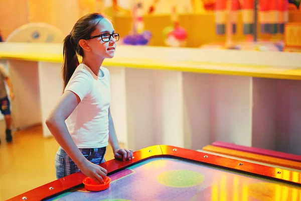 かわいい女の子が遊園地で空気ホッケー アーケード ゲーム機での再生 — ストック写真